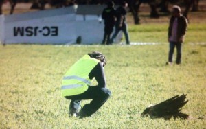 Un miembro de los equipos de rescate  inspecciona los restos del ave. Al fondo se puede apreciar el ala separada del resto de la aeronave.